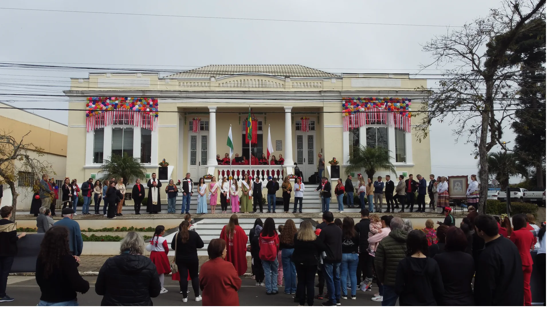 Apresentação do desfile de abertura diante de edifício histórico decorado com as cores da Polônia.